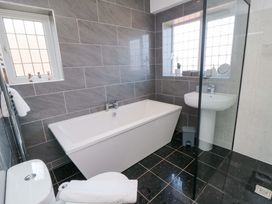 A bathroom featuring a bath tub, sink, toilet, and shower at 60 Muston Road in Filey
