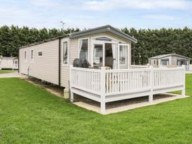 A mobile home with a deck and lawn at Kelly's Retreat Scarborough