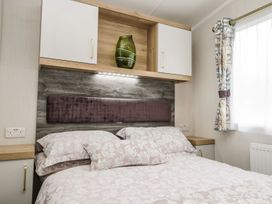 A bedroom with a double bed and a wall-mounted shelf at Kelly's Retreat in Scarborough