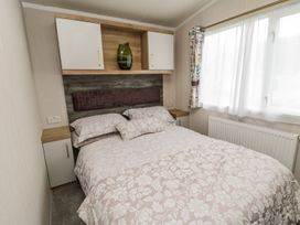 A bedroom with a double bed and cupboards at Kelly's Retreat in Scarborough