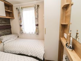 A bedroom with two beds and a wardrobe at Kelly's Retreat, Scarborough