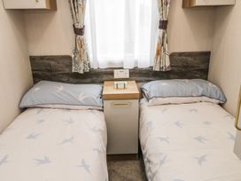 A bedroom with two single beds and a bedside table at Kelly's Retreat in Scarborough