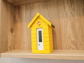 A yellow decorative house on a wooden shelf at Kelly's Retreat in Scarborough