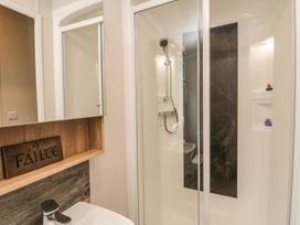 A bathroom featuring a shower, toilet, mirror, and sink at Kelly's Retreat in Scarborough