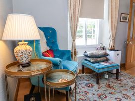 A living room with a blue chair and a side table at Seacroft in Combe Martin