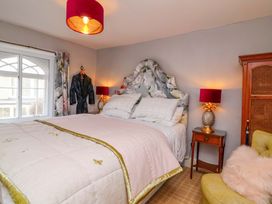 A bedroom with a bed and armchair at Seacroft in Combe Martin