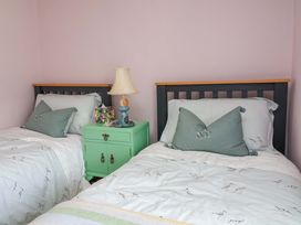 A bedroom with two beds and a bedside table at Seacroft in Combe Martin