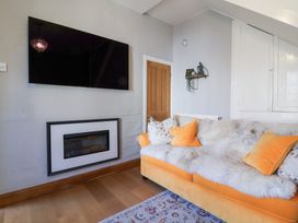 A living room with a television and a sofa at Seacroft Cottage in Combe Martin