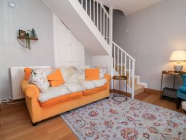 A living room with a sofa and staircase at Seacroft Cottage in Combe Martin