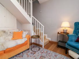 A living room with stairs and seating at Seacroft Cottage in Combe Martin