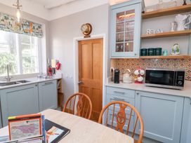 A kitchen with a sink and shelves at Seacroft Cottage Combe Martin