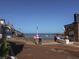 A seaside view with boats, a cafe and people at Seacroft Cottage in Combe Martin