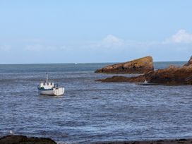 A boat on the water near rocks at Seacroft Cottage in Combe Martin