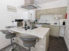 A kitchen with bar stools and appliances at Harbourside Apartments Whitehaven