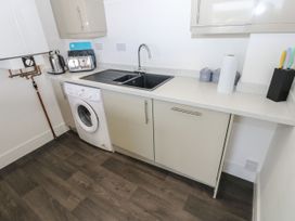 A kitchen with a sink and washing machine at Harbourside Apartments in Whitehaven