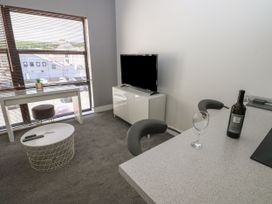A living room with a window and television at Harbourside Apartments in Whitehaven