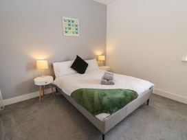 A bedroom with a bed and bedside tables at Harbourside Apartments Whitehaven