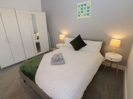 A bedroom with a bed and wardrobe at Harbourside Apartments in Whitehaven
