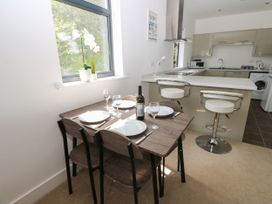 A dining room with a table and kitchen area at Seaview in Whitehaven