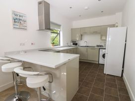 A kitchen with bar stools and appliances at Seaview in Whitehaven