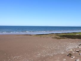 A beach with sand, seaweed and rocks at Seaview in Whitehaven
