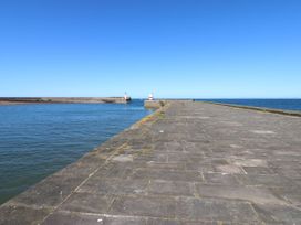 A pier with lighthouses on both ends and water surrounding at Seaview in Whitehaven