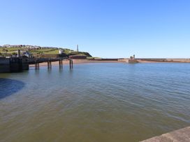 A view of a pier and water with hills and buildings at Seaview in Whitehaven