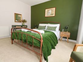 A bedroom with a bed and a nightstand at Otter Cottage in Weymouth
