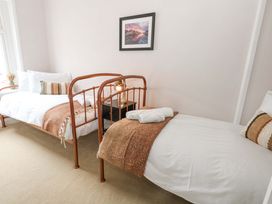 A bedroom with twin beds and a nightstand at Otter Cottage in Weymouth