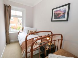 A bedroom with a bed and nightstand at Otter Cottage in Weymouth