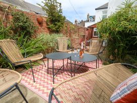 A garden with chairs and a table at Otter Cottage in Weymouth