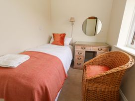 A bedroom with a bed, desk, chair and mirror at 31 Bull Lane in Dorchester