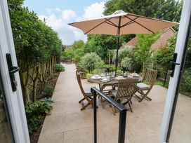 A garden with a table and chairs under a parasol at 31 Bull Lane in Dorchester
