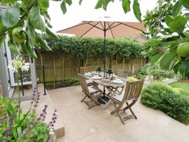A garden with a table and chairs under an umbrella at 31 Bull Lane in Dorchester