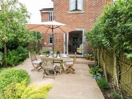 A garden with a table and chairs under an umbrella at 31 Bull Lane Dorchester