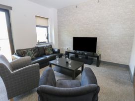 A living room with a television and seating at Quayside Apartments Whitehaven