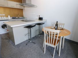 A kitchen with a round table and washing machine at Quayside Apartments in Whitehaven