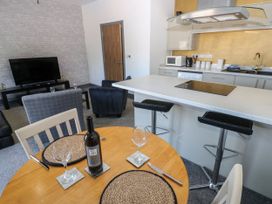 A kitchen and living area with a table and wine at Quayside Apartments Whitehaven