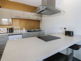 A kitchen with countertop, cabinets, washing machine, and appliances at Quayside Apartments Whitehaven