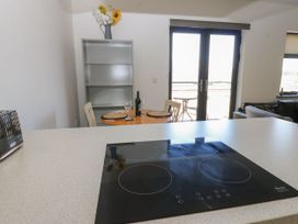 A kitchen with an electric hob and a table set for two at Quayside Apartments in Whitehaven
