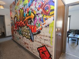 A hallway with graffiti on the wall and a view of a sitting area at Quayside Apartments in Whitehaven
