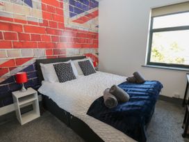 A bedroom with a bed and lamp at Quayside Apartments Whitehaven
