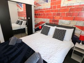 A bedroom with a bed and a mirrored wardrobe at Quayside Apartments in Whitehaven