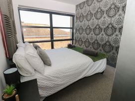 A bedroom with a bed and window at Quayside Apartments in Whitehaven