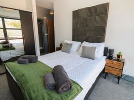 A bedroom with a bed and bedside table at Quayside Apartments in Whitehaven