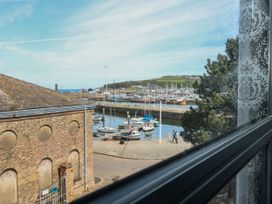 View of boats in a harbor from a window at Quayside Apartments in Whitehaven