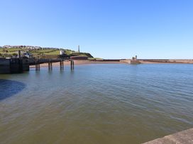 A view of a pier and water with a hill in the background at Quayside Apartments Whitehaven