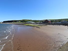 A beach with water and buildings at Quayside Apartments in Whitehaven
