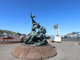 A sculpture near a harbor with boats at Quayside Apartments in Whitehaven