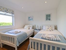 A bedroom with two beds and a nightstand at Stella Maris in Torpoint
